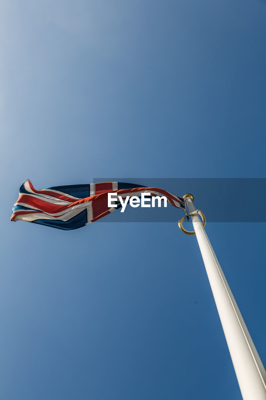 Low angle view of british flag against clear blue sky