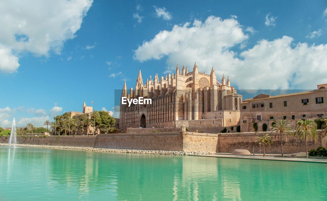 Church by lake against sky
