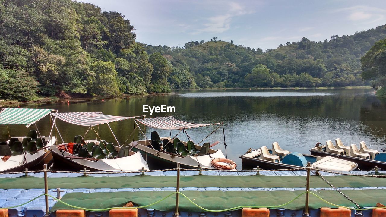 BOATS MOORED BY LAKE AGAINST SKY