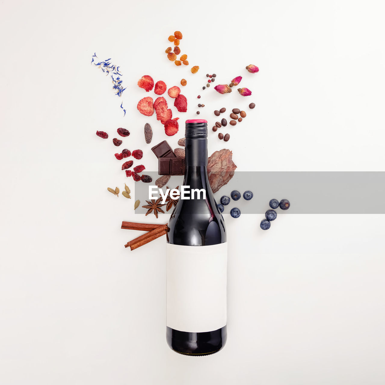 Composition with wine bottle and possible flavor components of red wine - berries, spices and other