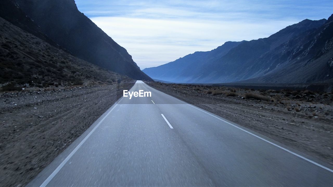 Empty road leading towards mountains