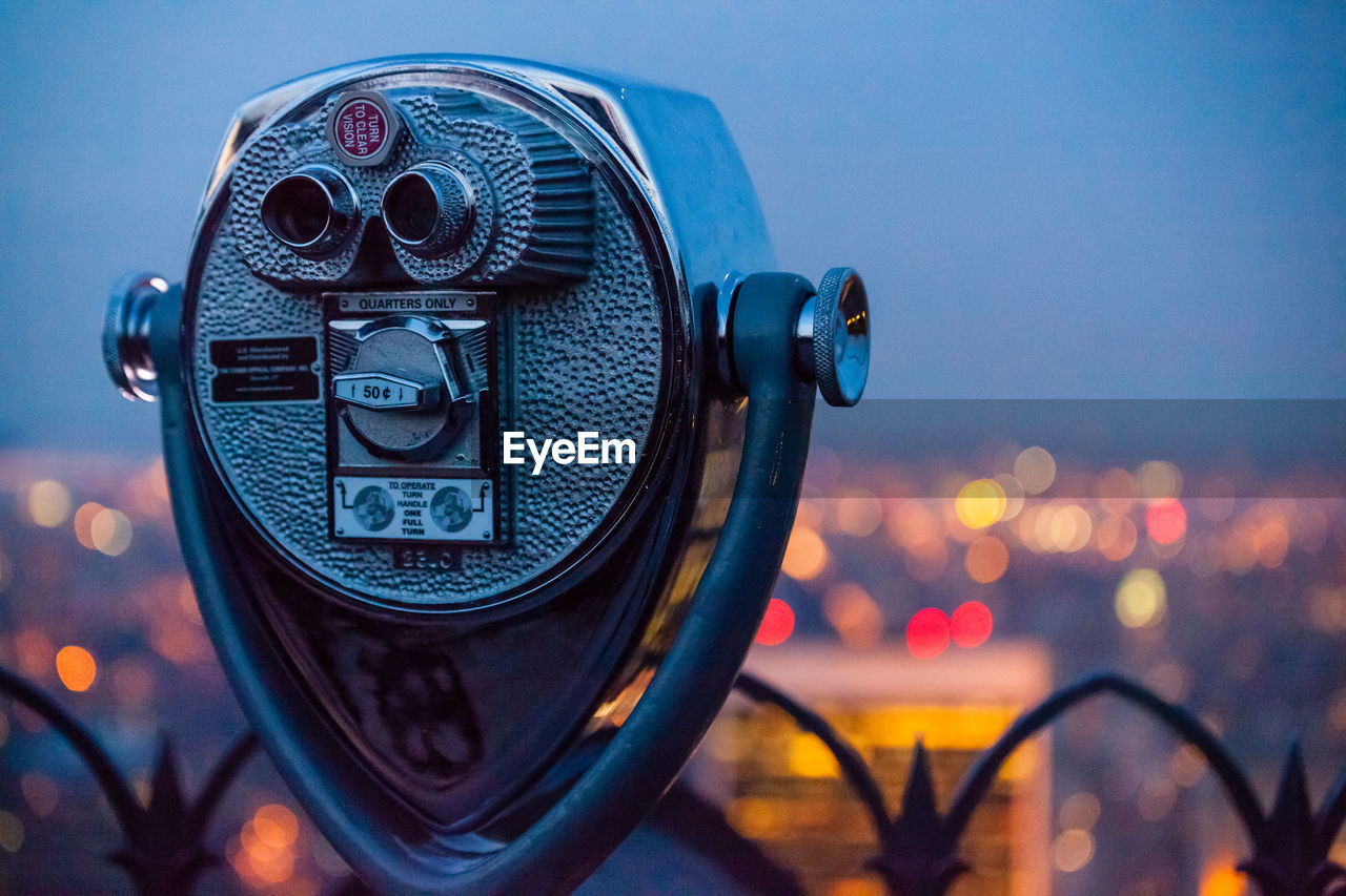 Close-up of coin-operated binocular against sky at dusk