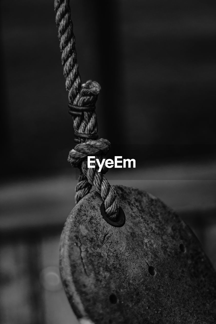 Close-up of rope tied on wooden plank