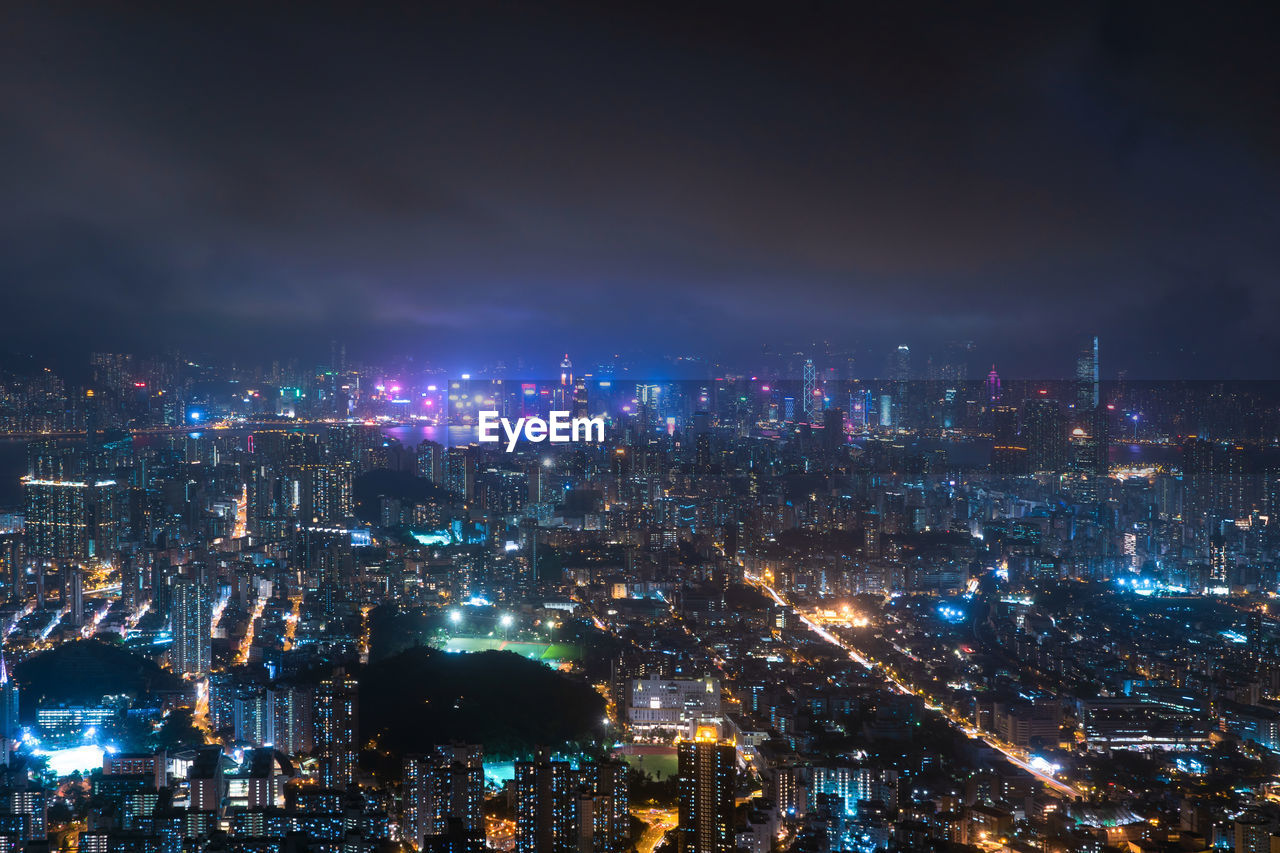 High angle view of illuminated city against sky at night