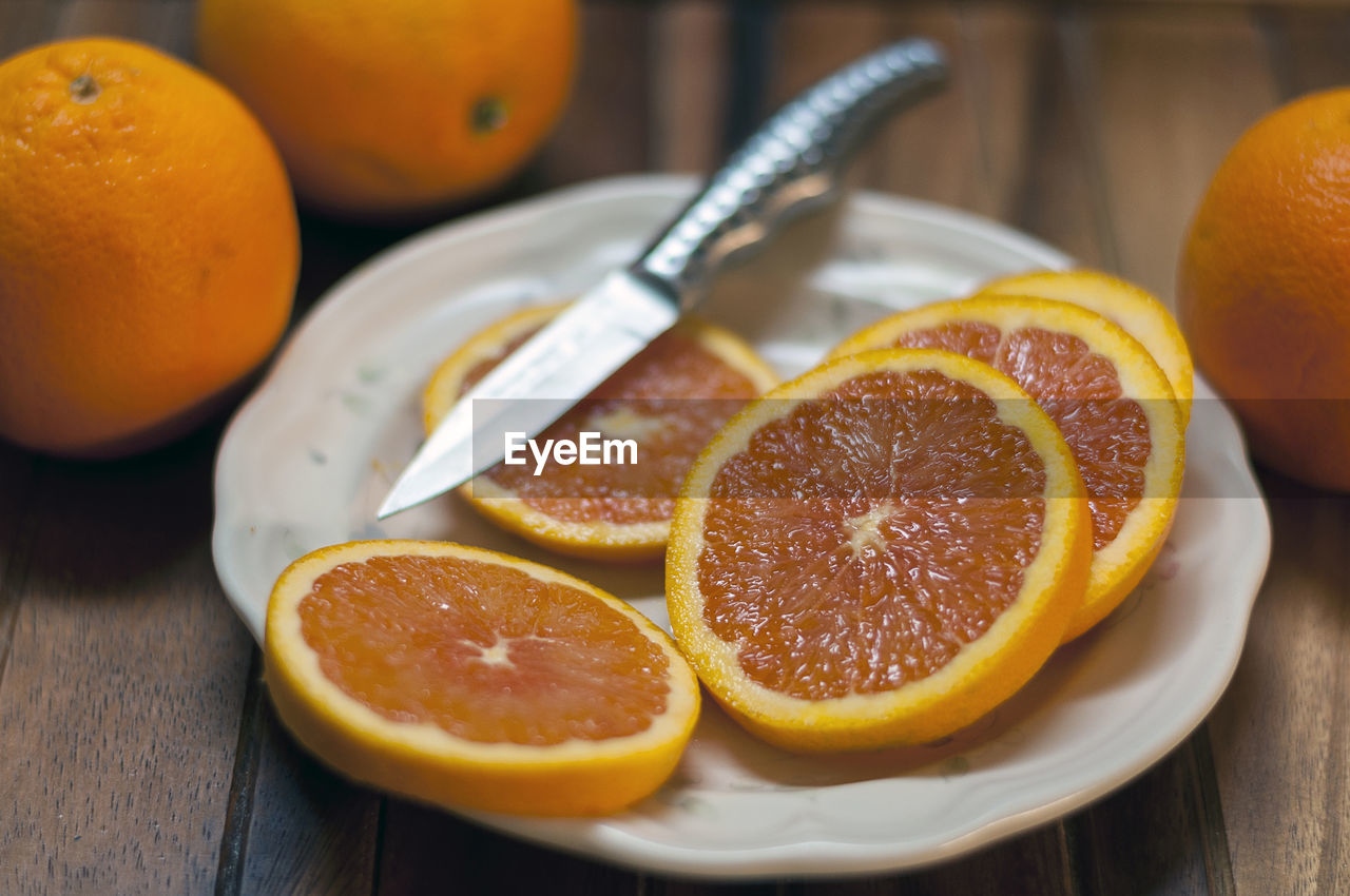 Close-up of orange fruits in plate on table