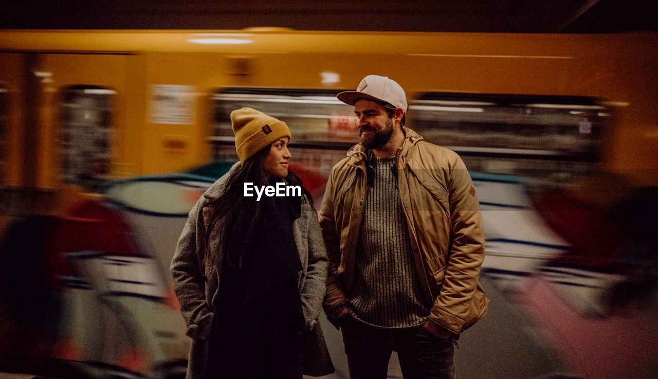 Couple standing by train at railroad station