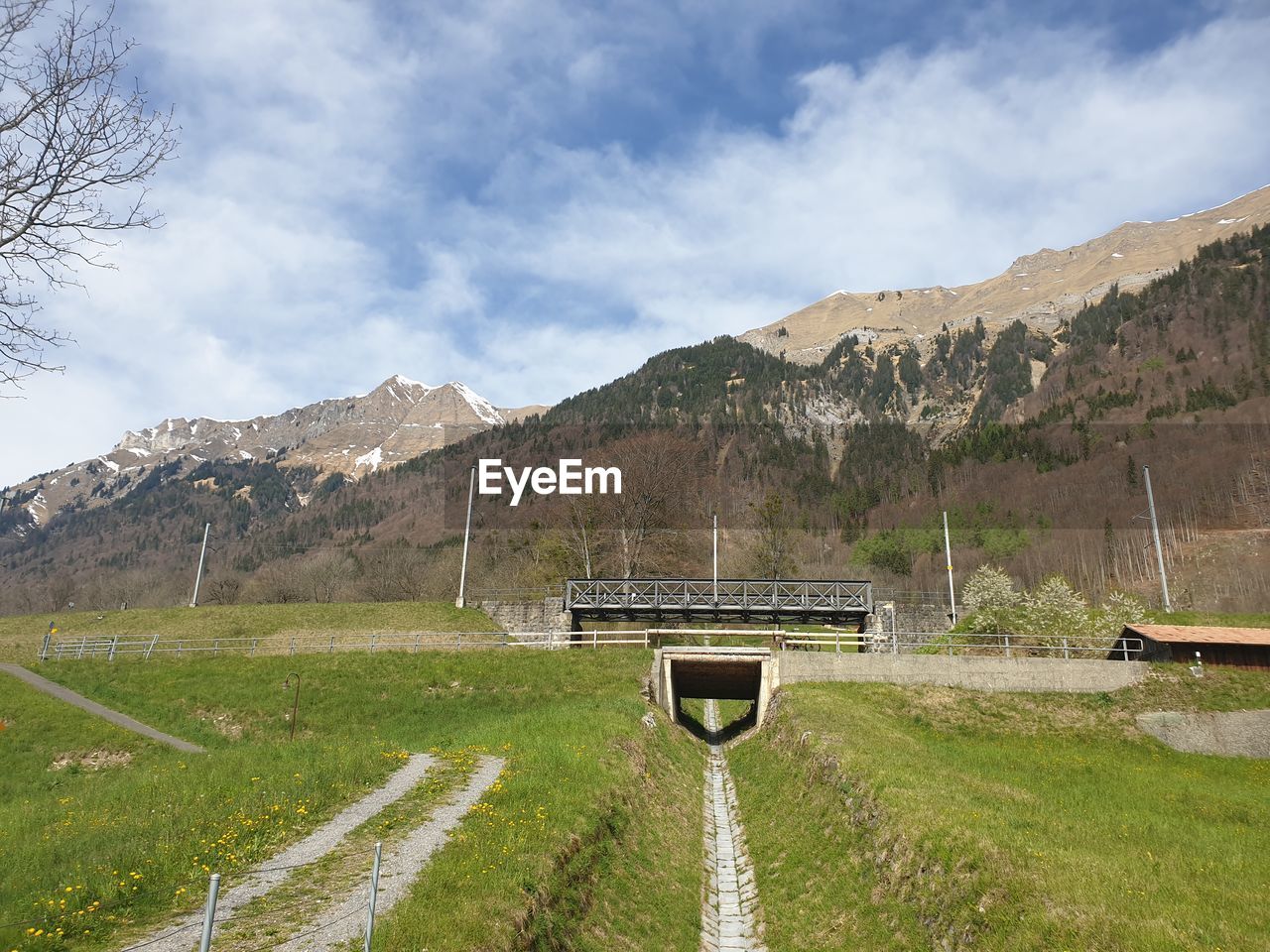 Built structure on field by mountains against sky