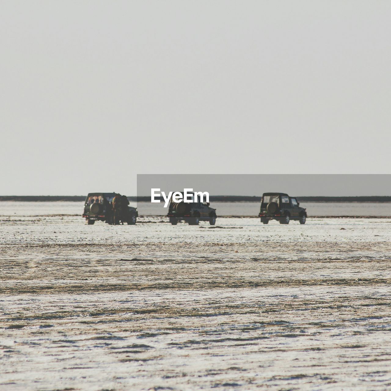 Jeeps parked on desert against sky