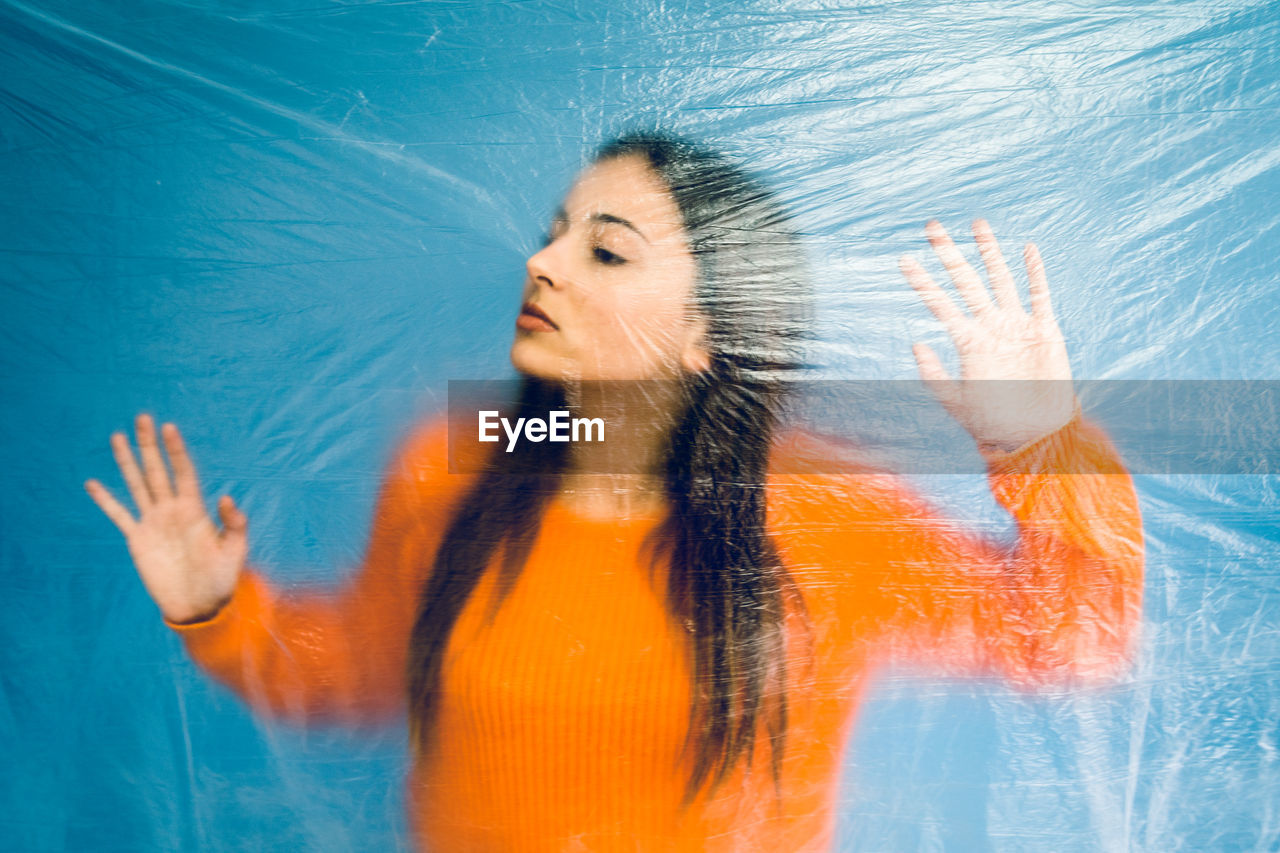 Thoughtful teenage girl trapped in plastic