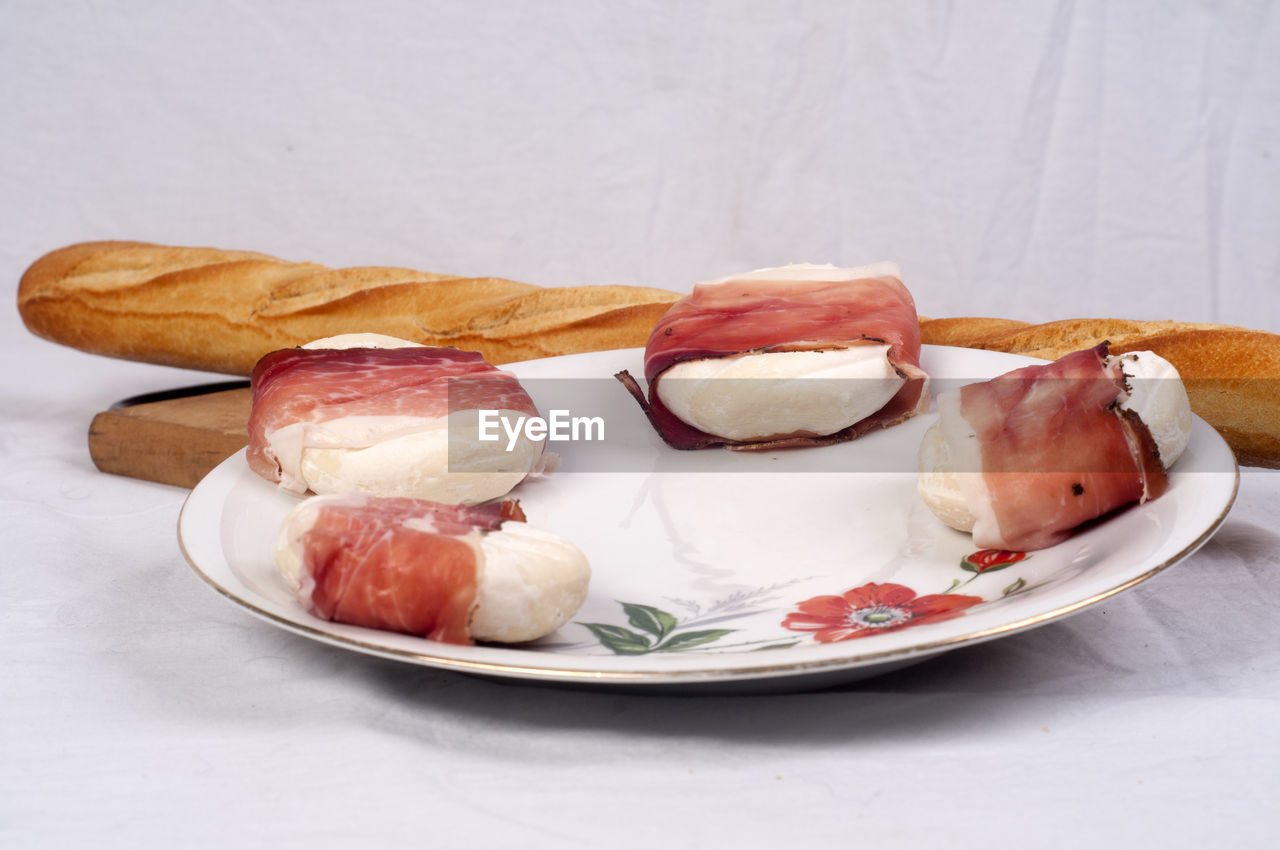 Bacon and tofu with baguette in plate on table