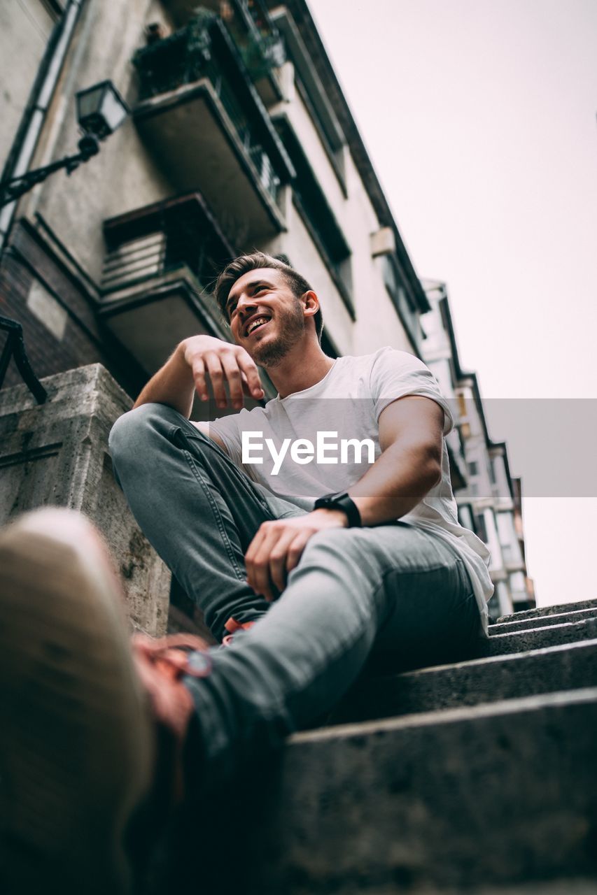 Low angle view of man sitting on staircase