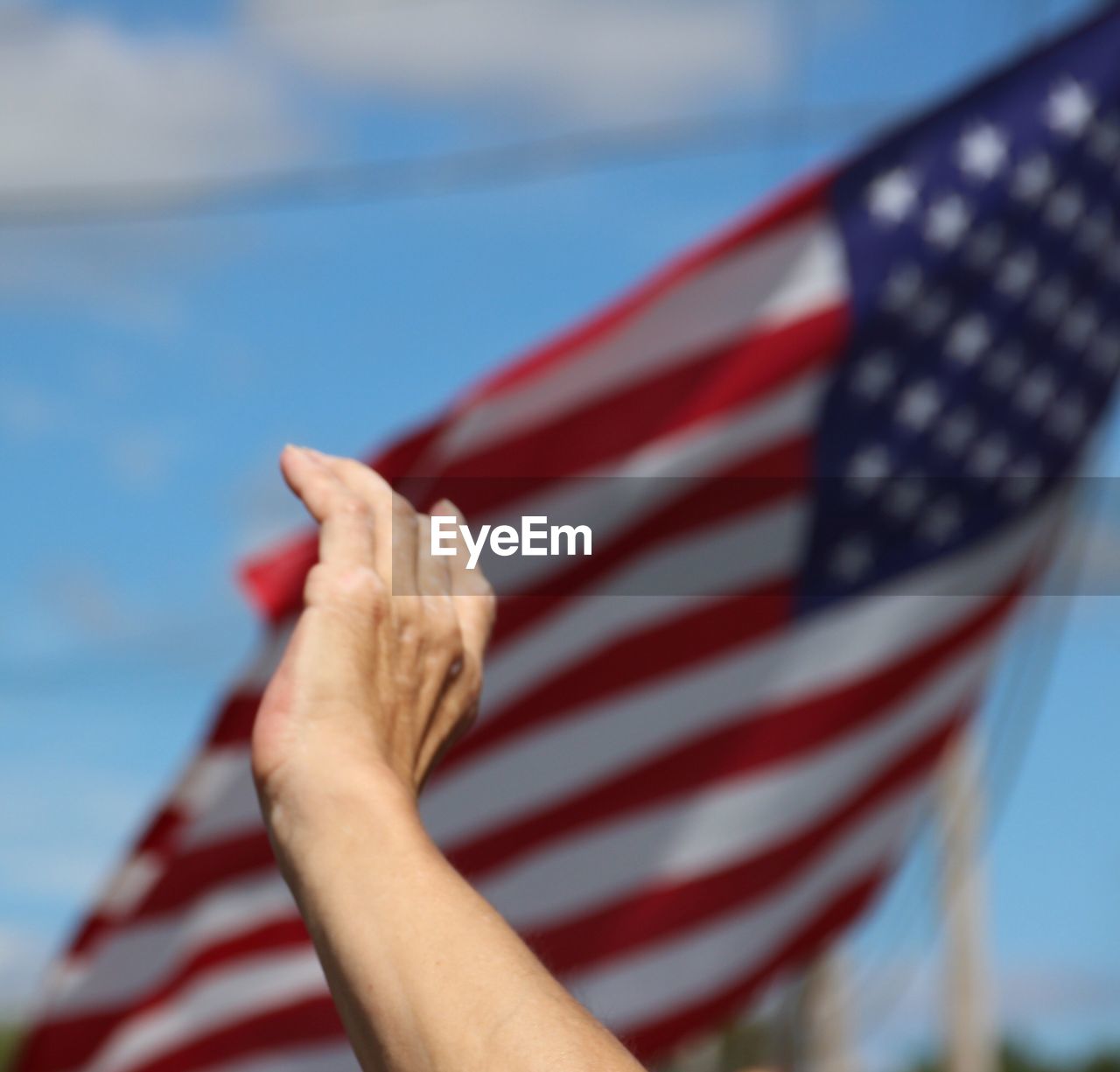 Cropped hand by american flag