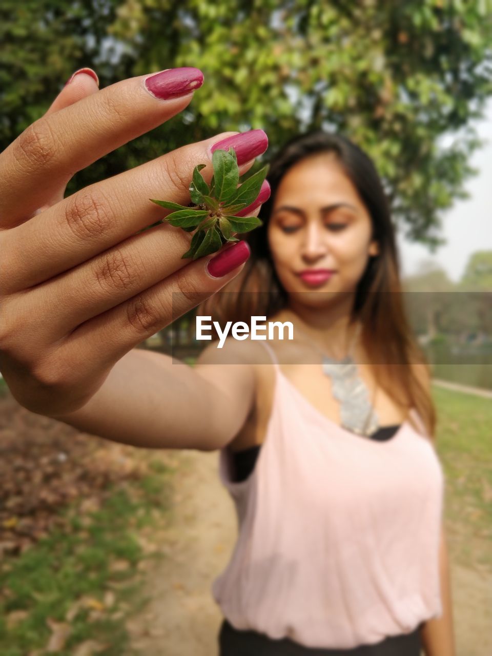 Beautiful young woman holding leaf