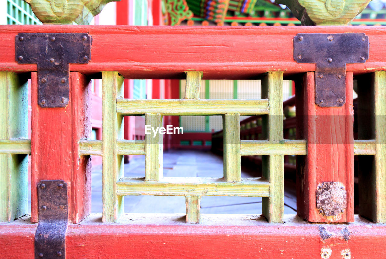 Patterned wooden squares looking into a walkway in a korean palace