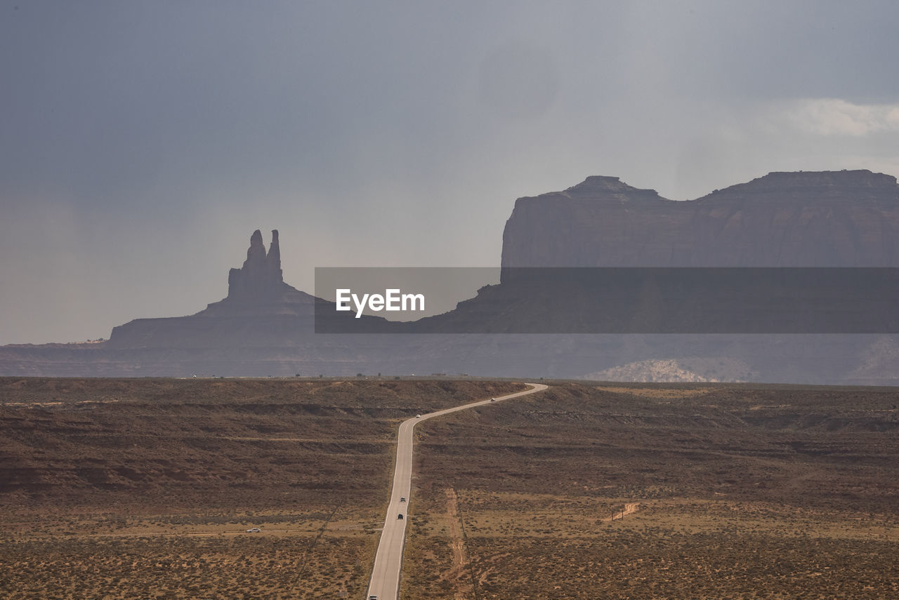 Aerial view of road leading towards monument valley with sky in background