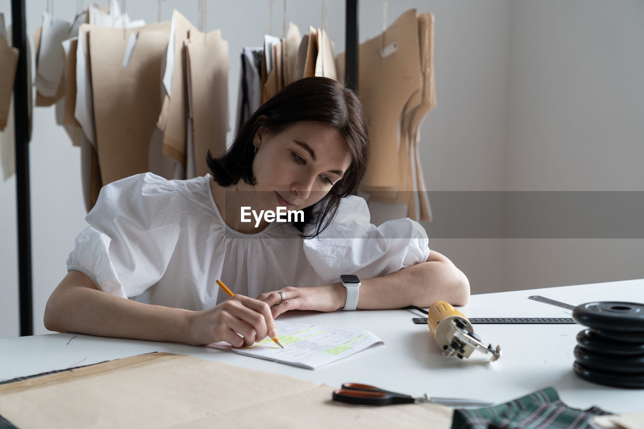 Woman looking at camera while sitting on table