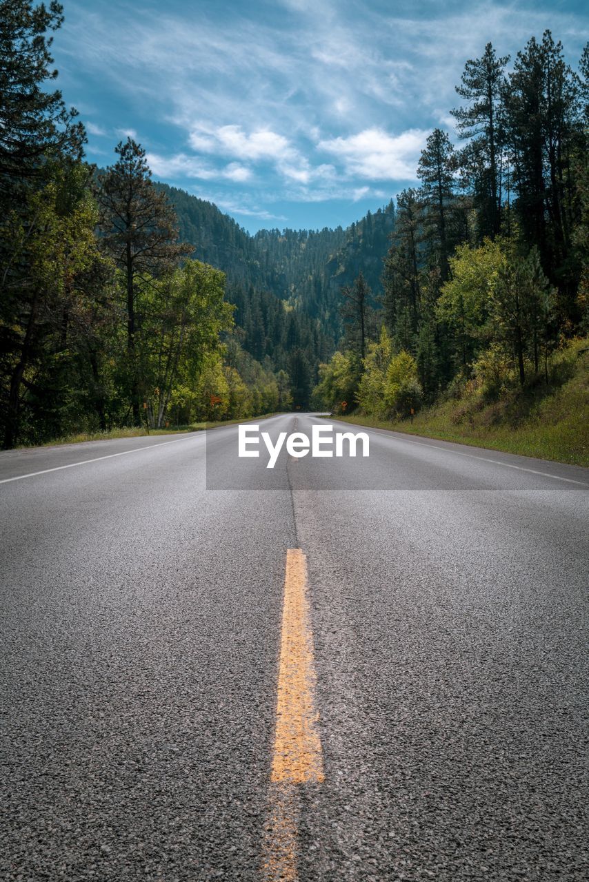 Road leading towards mountain against sky