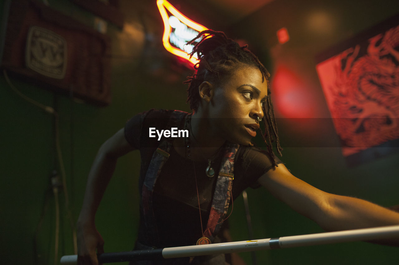 A young woman playing pool.