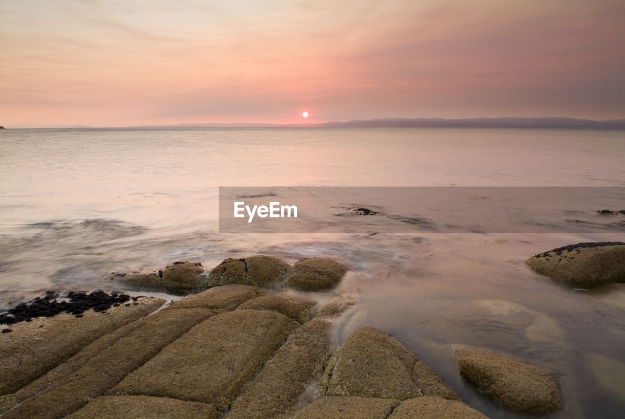 SCENIC VIEW OF SEA AGAINST ORANGE SKY