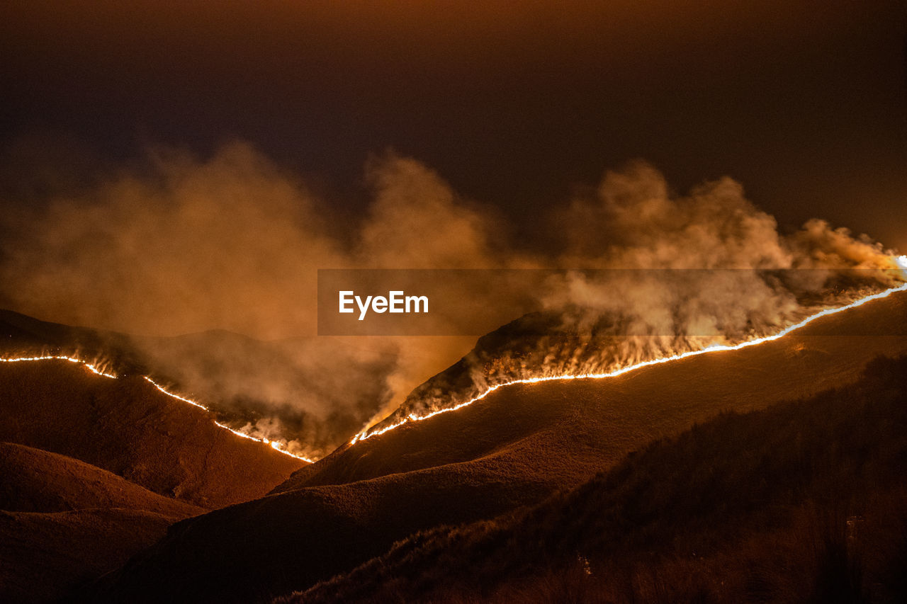 Panoramic view of volcanic mountains against sky at night