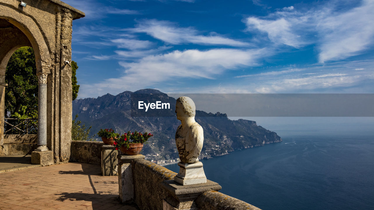 SCULPTURE AGAINST SEA AND MOUNTAINS