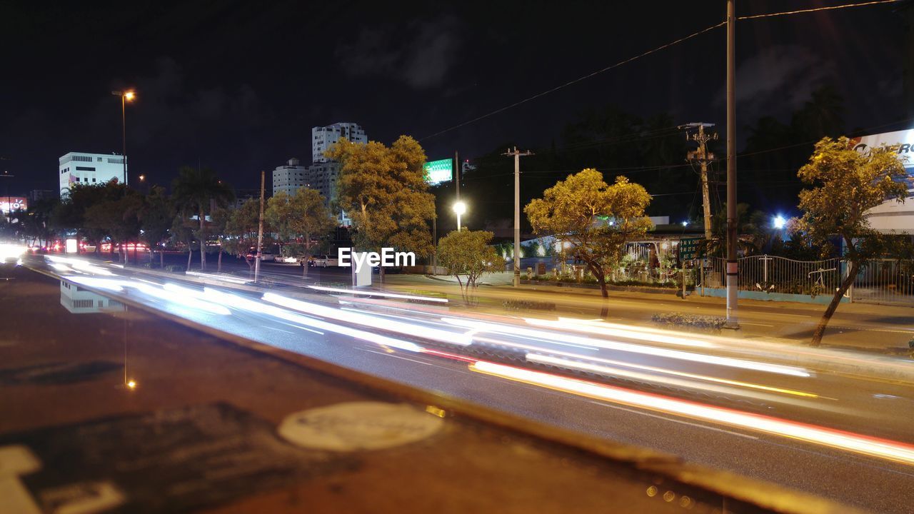 LIGHT TRAILS ON CITY STREET AT NIGHT