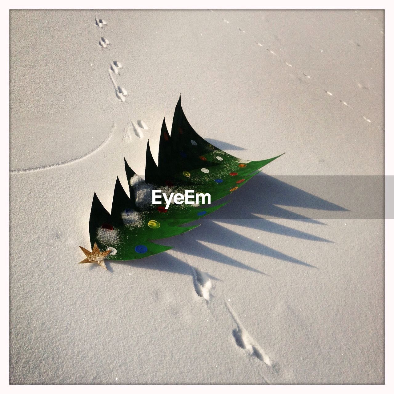 High angle view of artificial christmas tree with shadow on snow