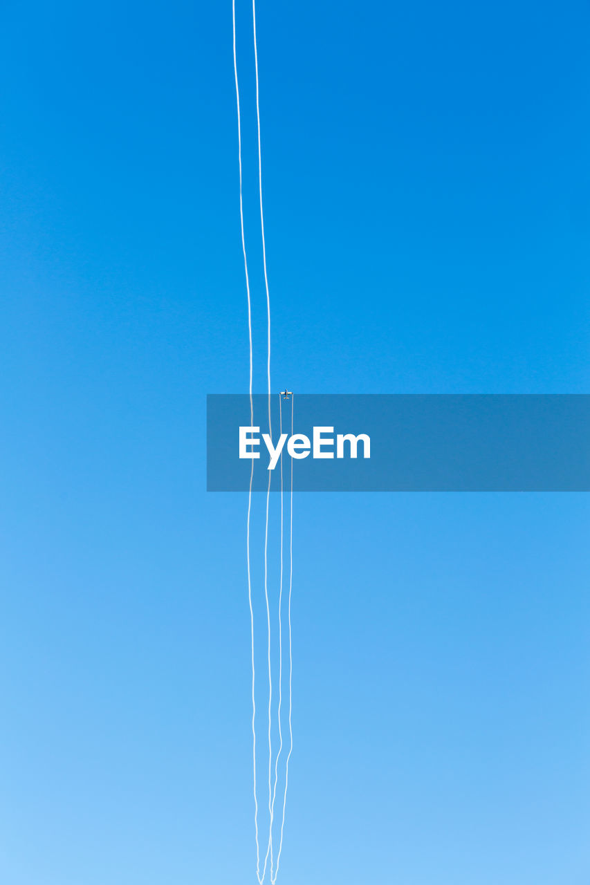 LOW ANGLE VIEW OF VAPOR TRAILS IN SKY