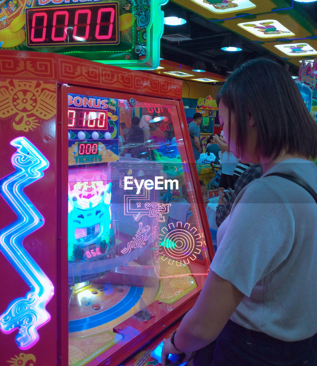 SIDE VIEW OF WOMAN LOOKING AT ILLUMINATED CAMERA