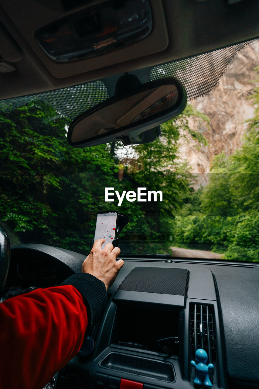 Man driving and using gps on his smartphone on mountain road
