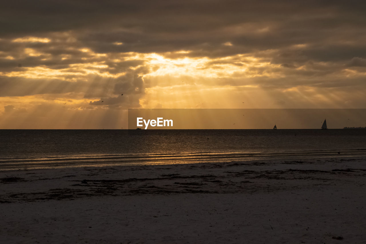 SCENIC VIEW OF BEACH AGAINST SKY AT SUNSET