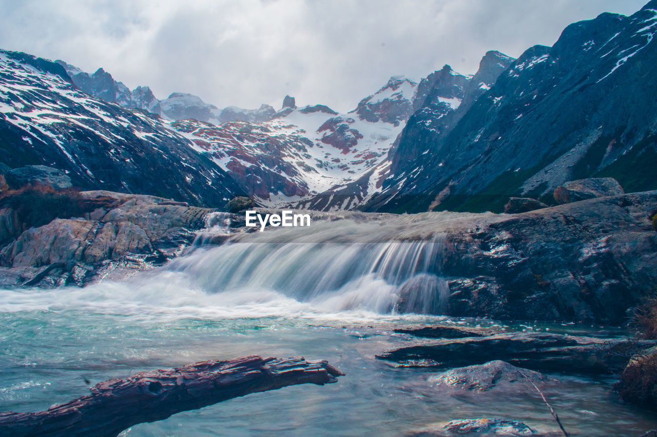 Scenic view of waterfall against sky