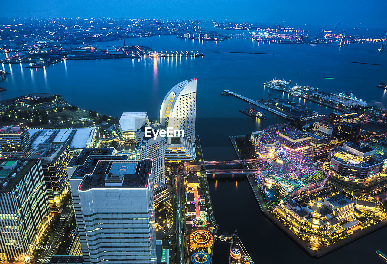 High angle view of illuminated buildings by river at night