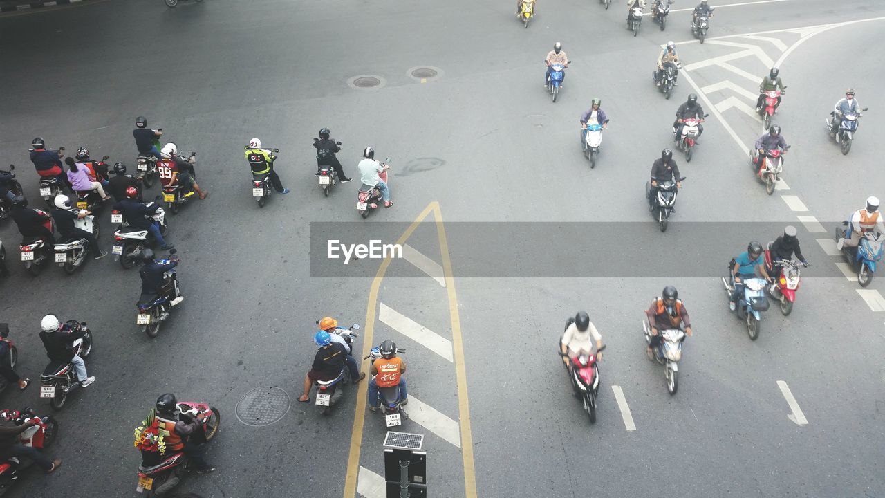 High angle view of people with motorcycles on road in city