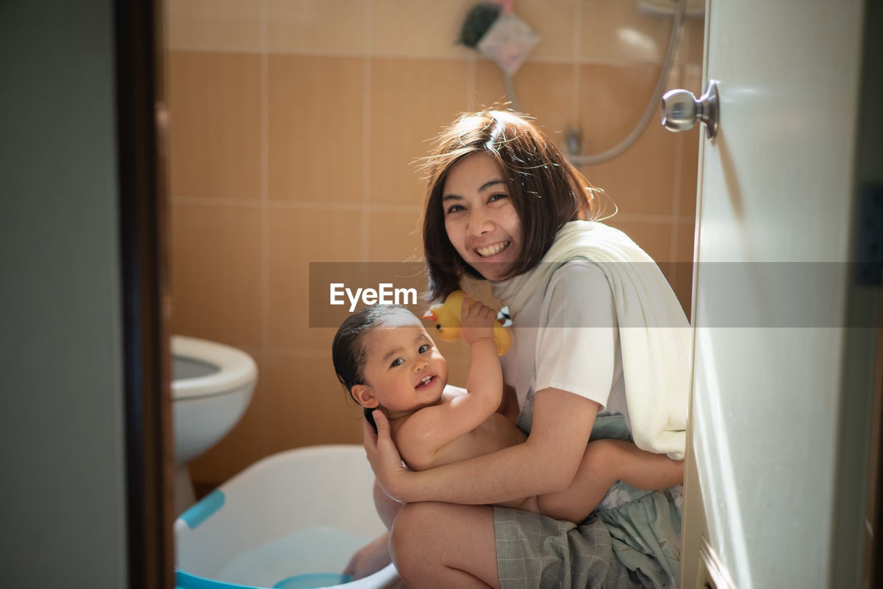 Portrait of mother and girl in bathroom