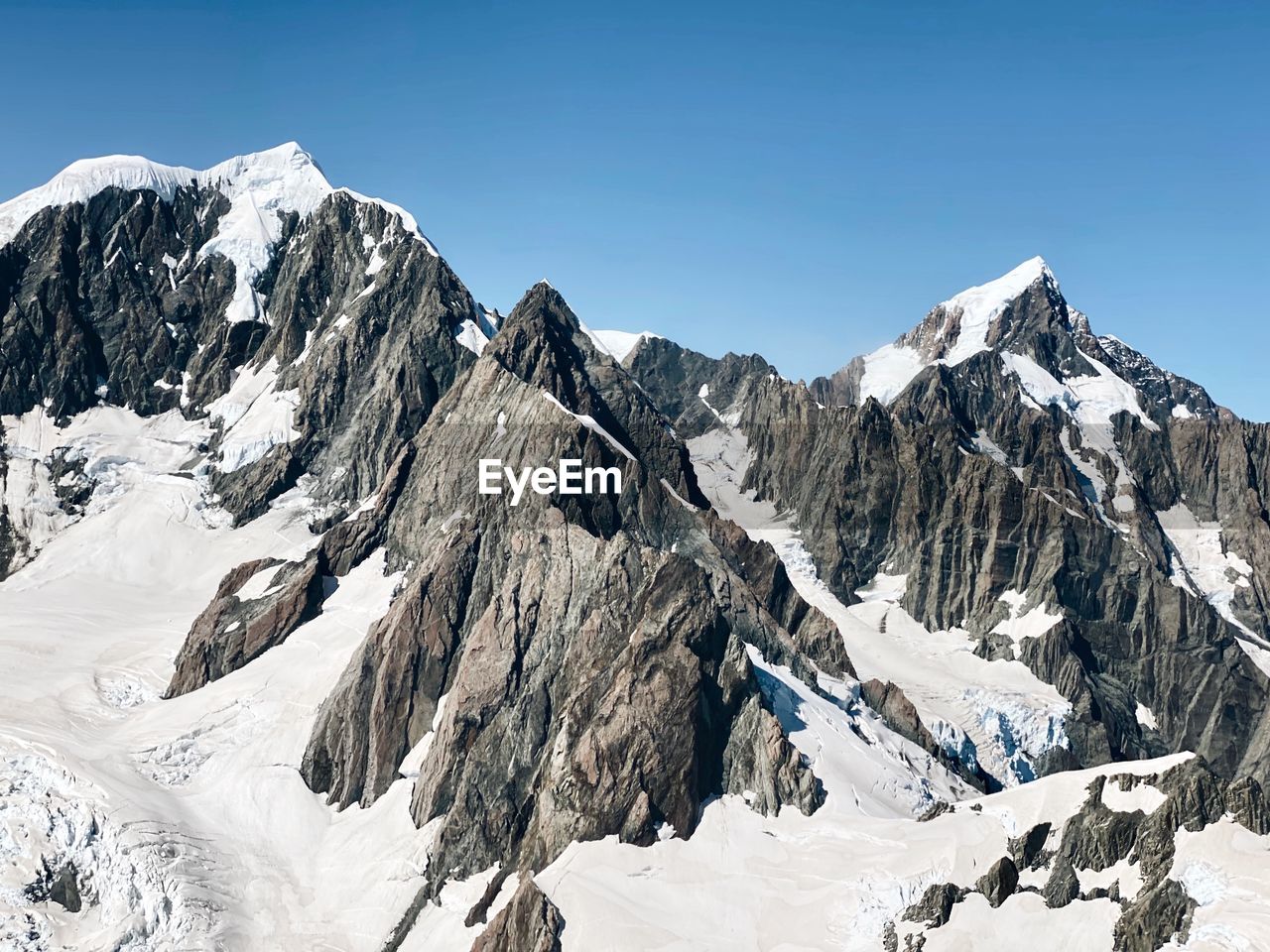 Scenic view of snowcapped mountains against clear sky 