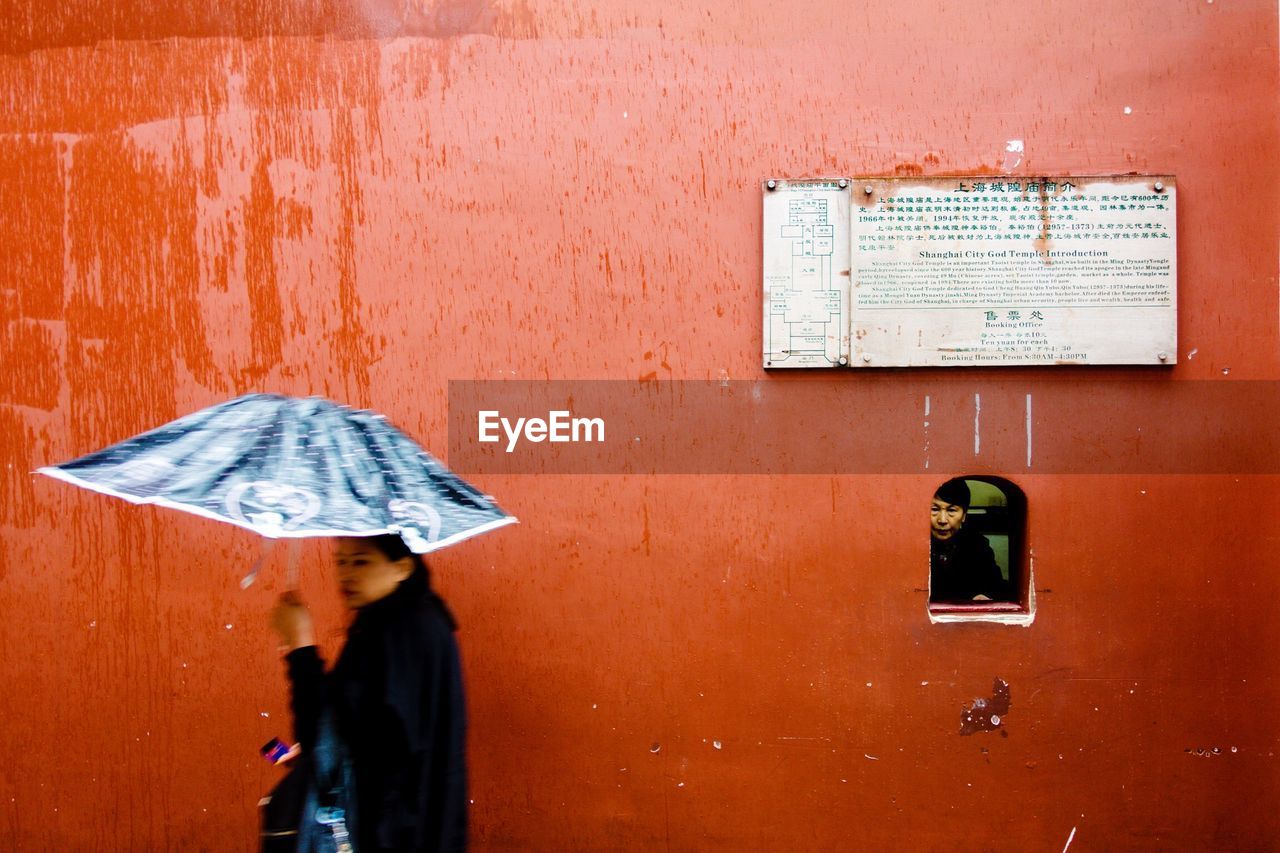 MAN STANDING AGAINST WALL