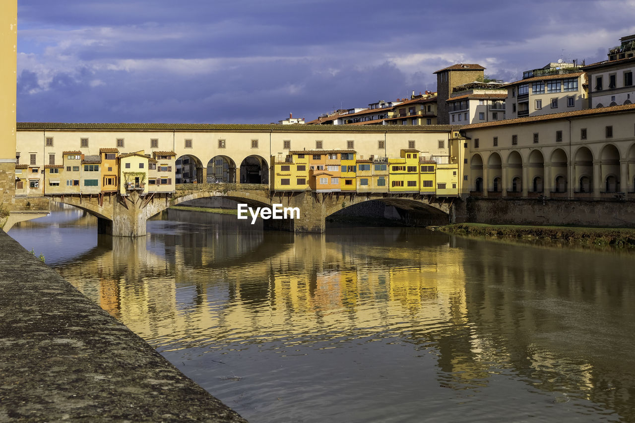 Ponte vecchio over arno river with its colorful little houses hanging - florence, tuscany, italy