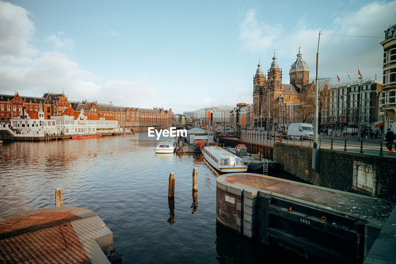 Boats moored in river against buildings in city