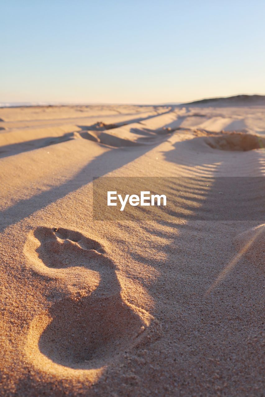 SCENIC VIEW OF SAND DUNE AGAINST SKY