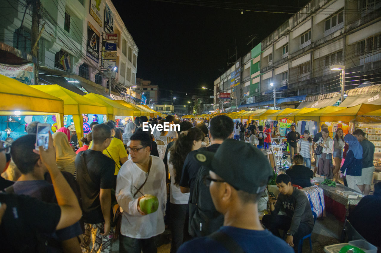 CROWD IN ILLUMINATED CITY