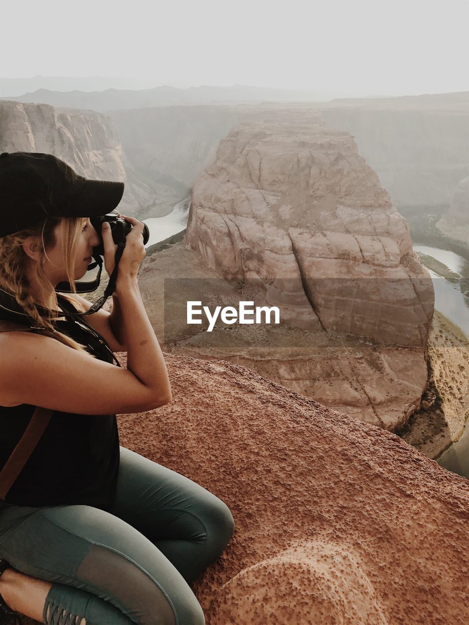 Young woman photographing horseshoe bend through camera