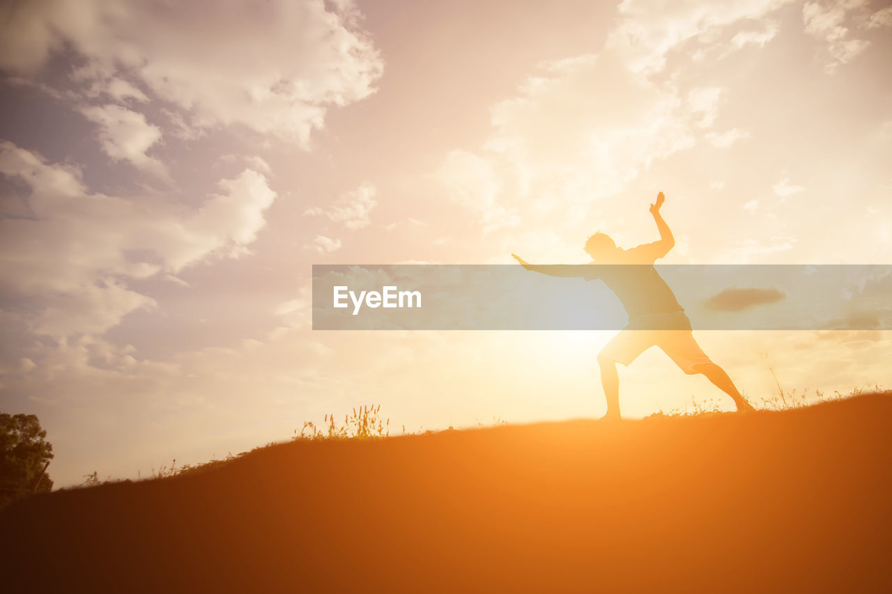 Silhouette man standing against sky during sunset