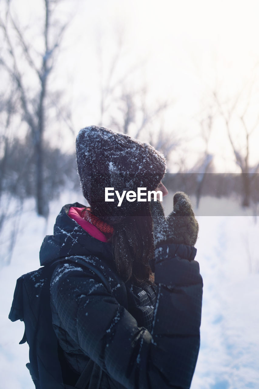 Beautiful woman having fun in snowy forest. winter outdoors activity