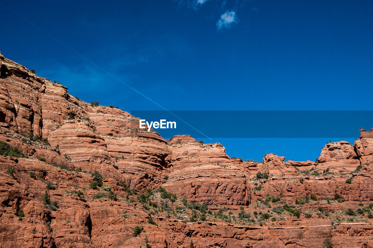 Low angle view of rock formation against clear blue sky