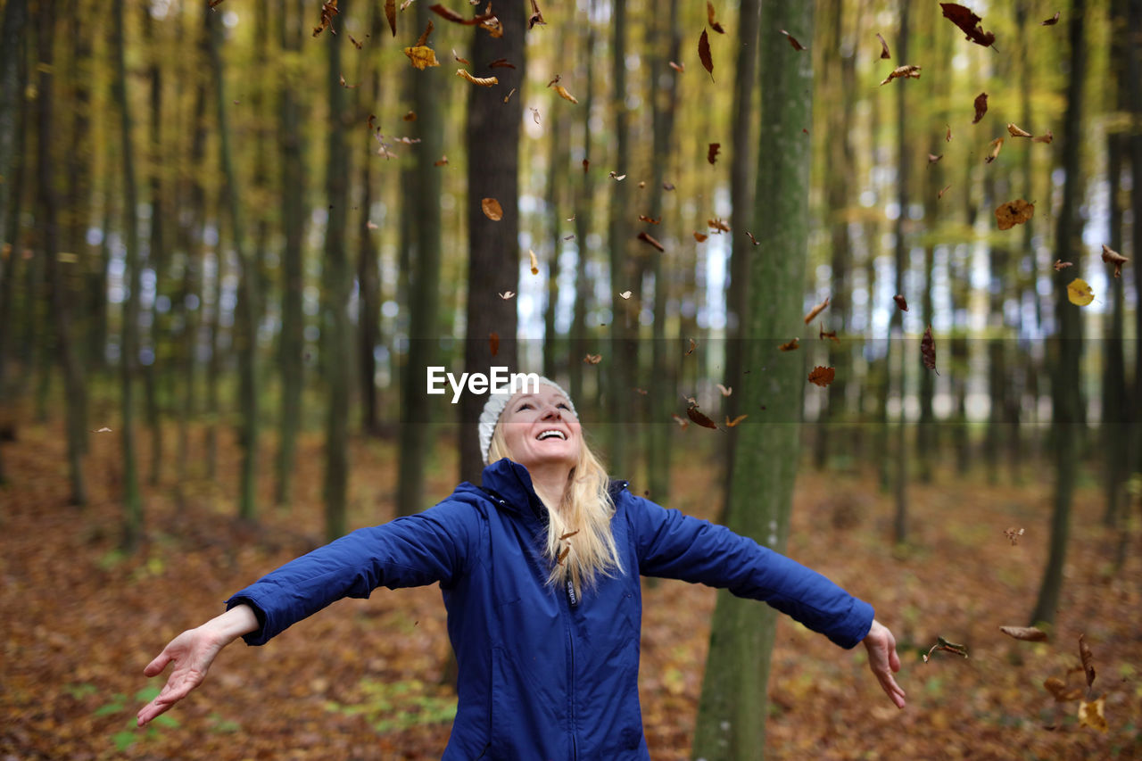 Portrait of young woman standing in forest