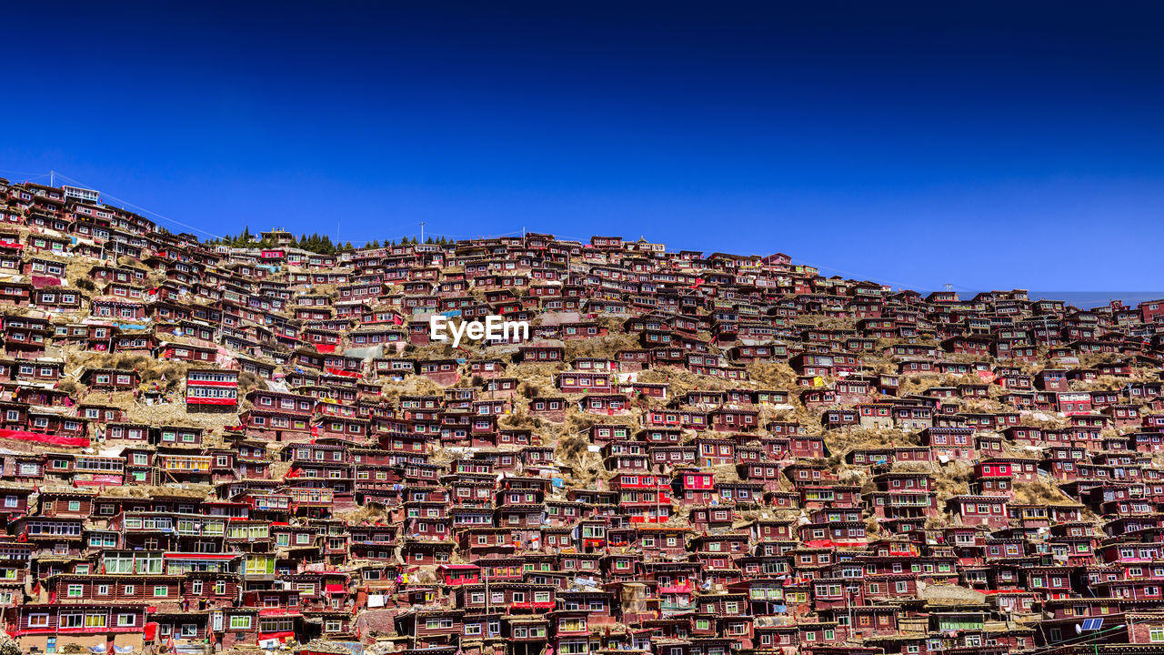 LOW ANGLE VIEW OF CITYSCAPE AGAINST CLEAR BLUE SKY