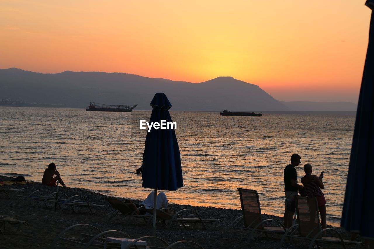 SILHOUETTE PEOPLE AT BEACH DURING SUNSET