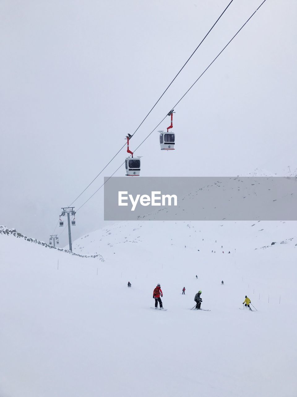 People skiing over ski lift during winter