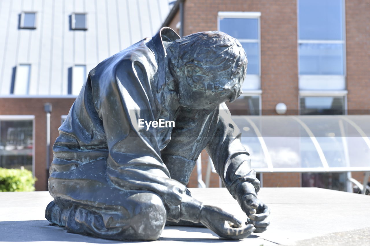 STATUE OF MAN AND BUILDING